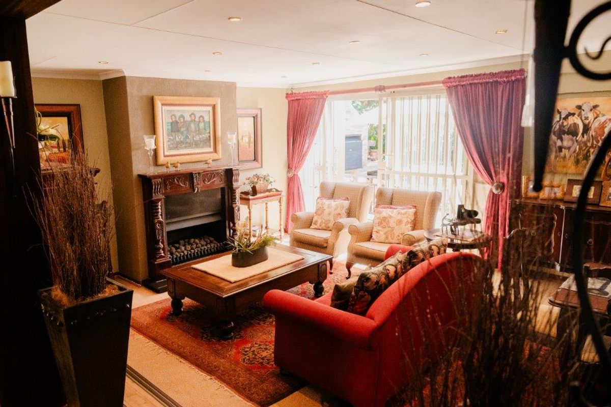 A cozy living room featuring a traditional fireplace, recessed ceiling lighting, and sliding glass doors providing access to the outdoor area.