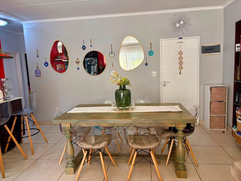 A dining area featuring tiled flooring and a neutral wall finish, providing a functional space for meals.
