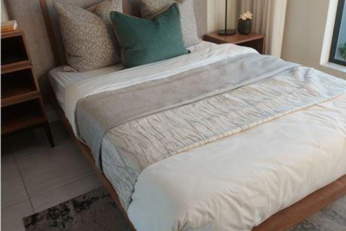 A well-maintained bedroom featuring neutral tiled flooring and modern finishes, providing a comfortable and inviting living space.