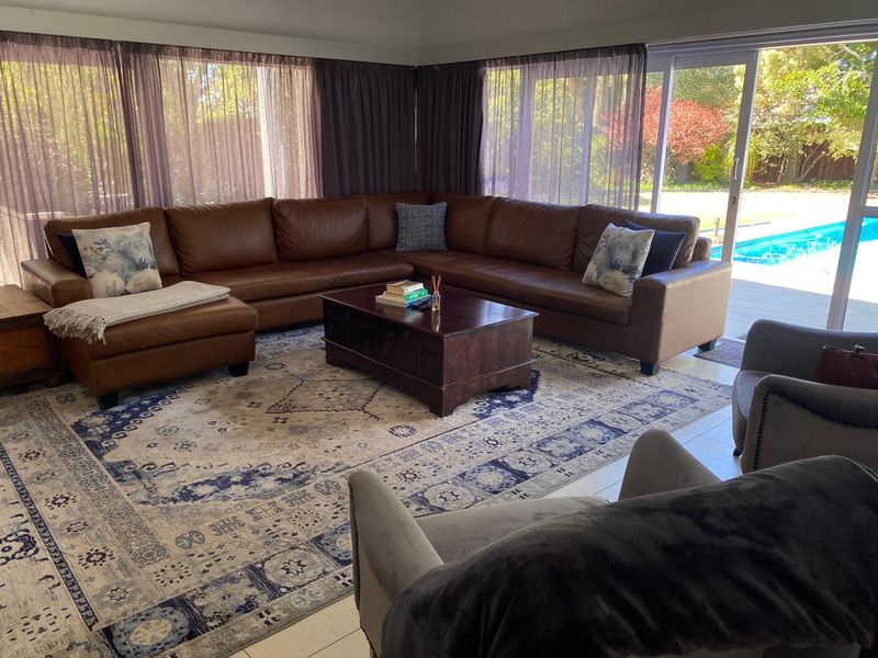 Spacious living room featuring large sliding glass doors that provide direct access to the outdoor pool area and garden.