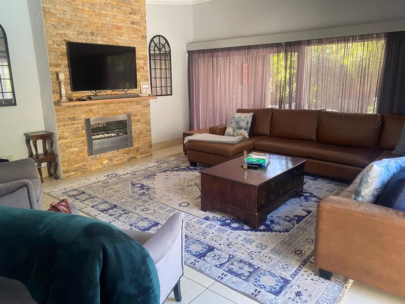 Spacious living room featuring a prominent stone-clad fireplace with a built-in gas insert and large sliding doors providing natural light.