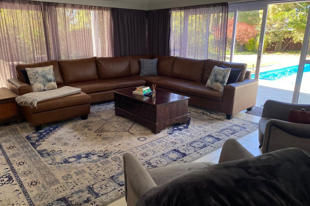 Spacious living room featuring large sliding glass doors that provide direct access to the outdoor pool area and garden.