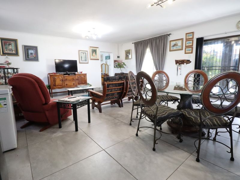 Spacious open-plan living and dining area featuring large format floor tiles and sliding glass doors leading to the exterior.