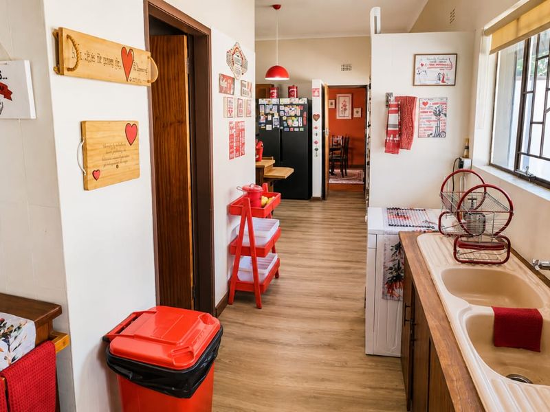 A functional kitchen area featuring a double basin sink, laminate flooring, and direct access to adjacent living spaces.