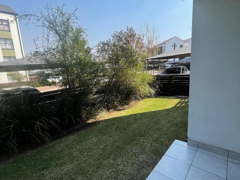 A private ground-floor patio featuring tiled flooring and a small, well-maintained garden area with timber fencing.