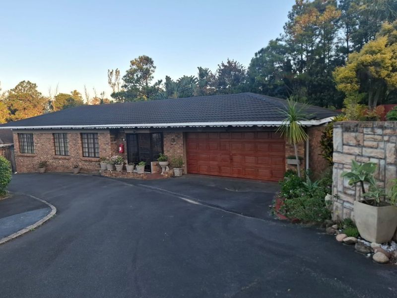 Front exterior view of a brick townhouse featuring a tiled roof, integrated garage, and paved driveway access.