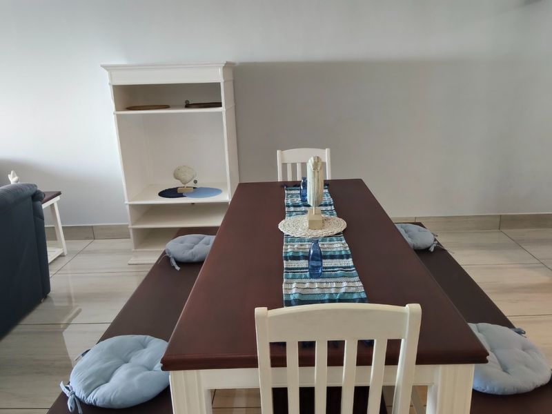 A dining area featuring tiled flooring and neutral wall finishes, providing a functional space for meals.