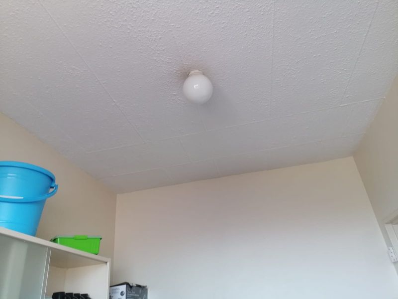 A view of a room interior featuring a textured ceiling with a basic light fixture.
