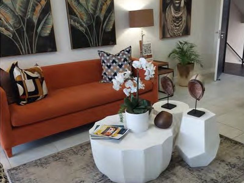 A well-maintained living room featuring neutral tiled flooring and clean wall finishes, providing a bright and inviting space.