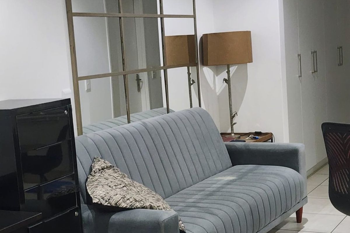 A living area featuring tiled flooring and built-in storage cupboards, providing a functional space with neutral finishes.