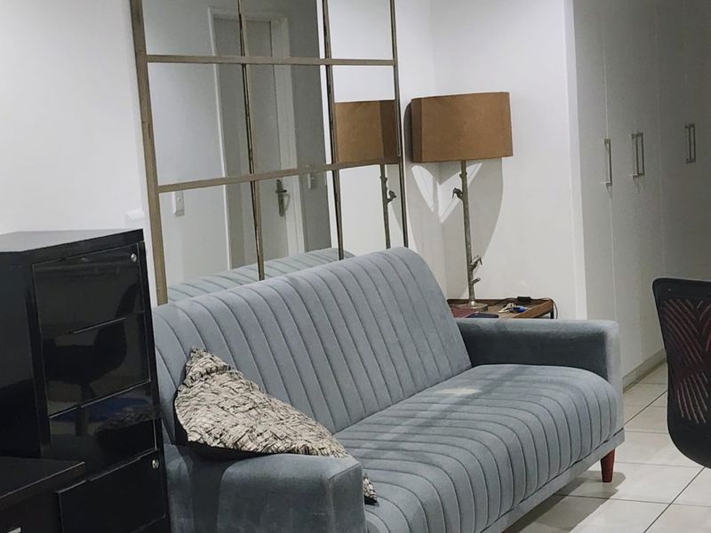 A living area featuring tiled flooring and built-in storage cupboards, providing a functional space with neutral finishes.
