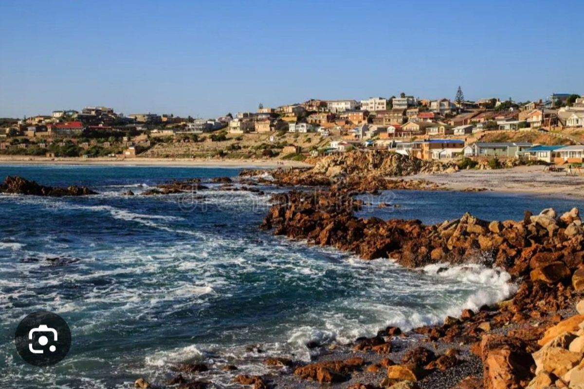 A scenic coastal view overlooking the rocky shoreline and the surrounding residential neighbourhood.