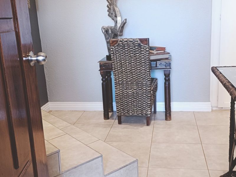 A welcoming entry area featuring neutral tiled flooring and a solid wood door, providing a clean and functional transition space.