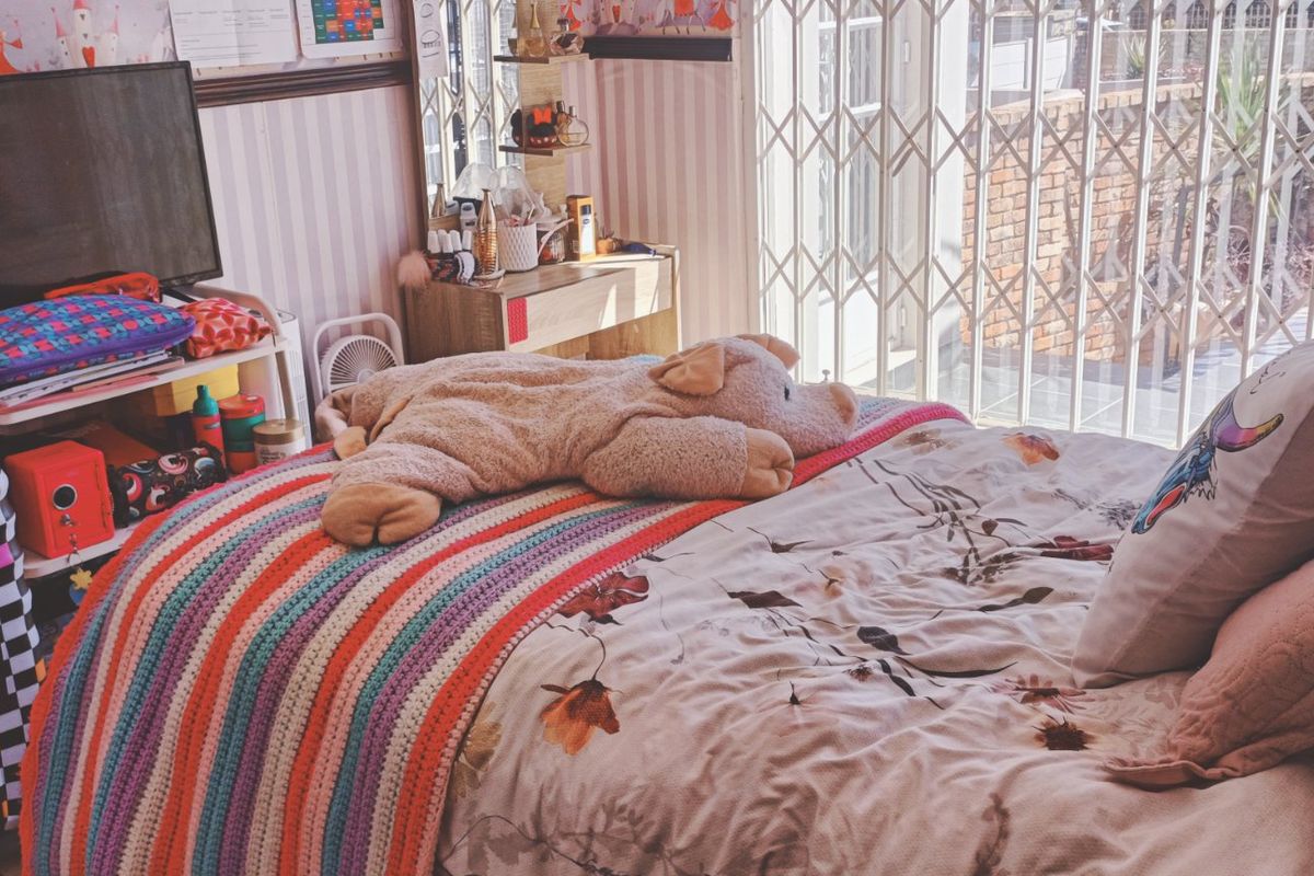 A bedroom featuring a sliding door with a fitted security gate, providing access to the exterior.