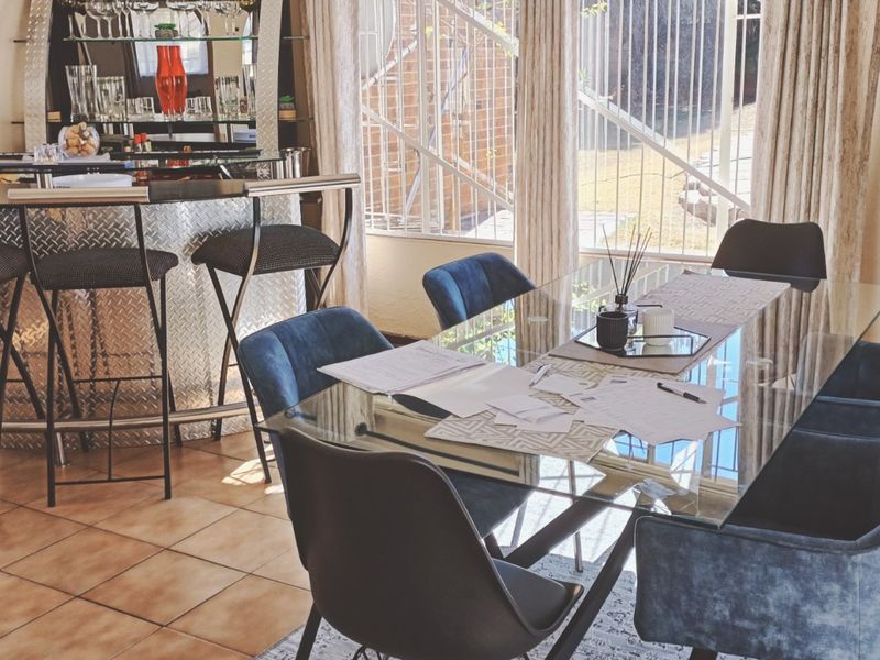 A dedicated bar area featuring a built-in counter, tiled flooring, and large windows providing natural light and views of the exterior.
