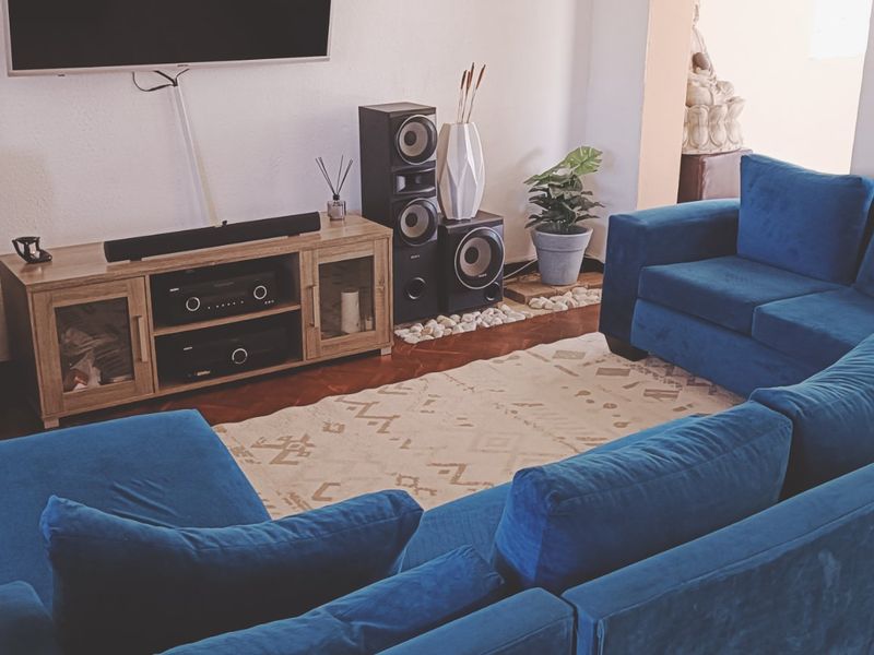 A comfortable living room featuring tiled flooring and a stone feature wall, providing a cozy space for relaxation and entertainment.