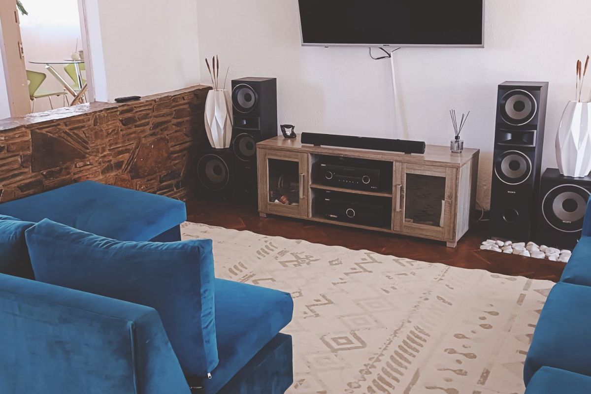 A cozy living room featuring a distinctive stone accent wall and classic parquet flooring, creating a warm and inviting atmosphere.
