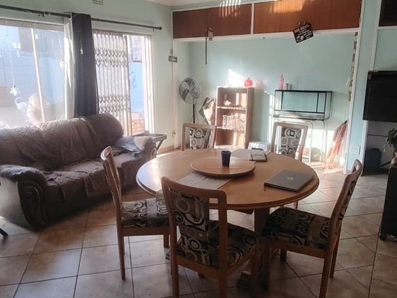 A living area featuring tiled flooring, built-in overhead storage cabinets, and a sliding glass door providing access to the exterior.