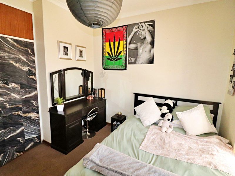 A bedroom featuring carpet flooring and a built-in wardrobe with a dark marble-effect finish.