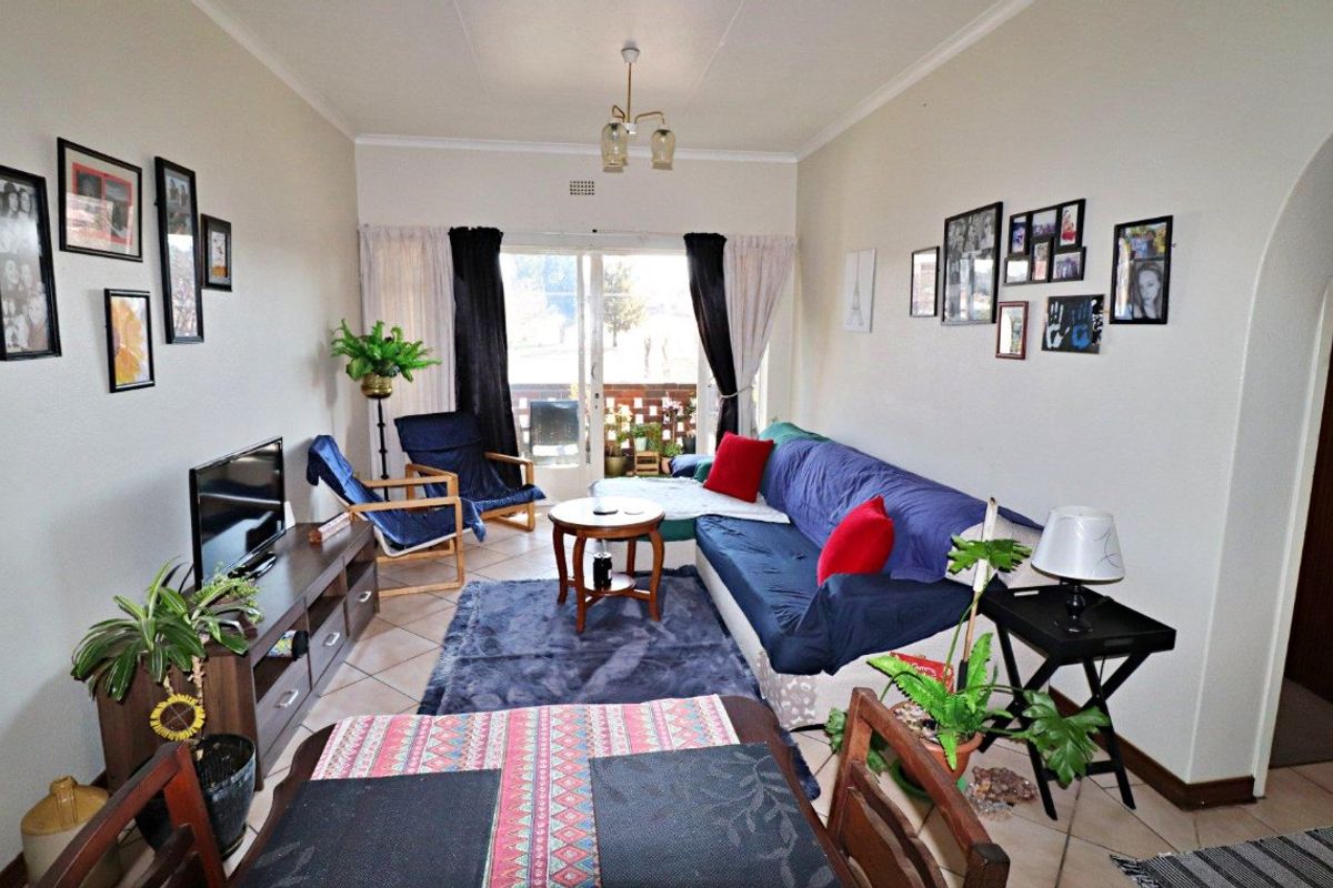 A comfortable living room featuring tiled flooring and a sliding glass door that provides access to an outdoor area.