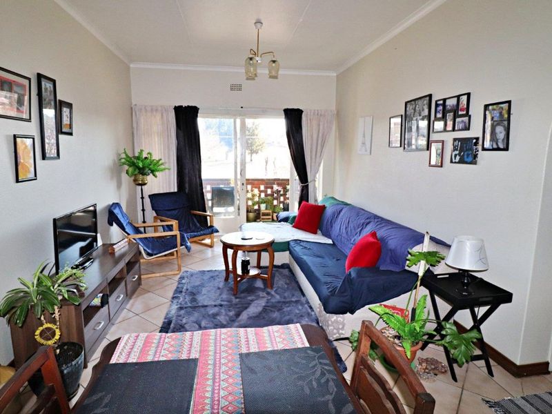 A comfortable living room featuring tiled flooring and a sliding glass door that provides access to an outdoor area.