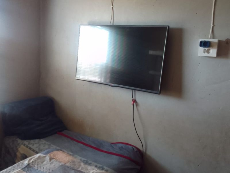 A bedroom featuring unfinished wall surfaces and exposed electrical wiring, requiring cosmetic updates to improve the overall finish and aesthetic appeal.