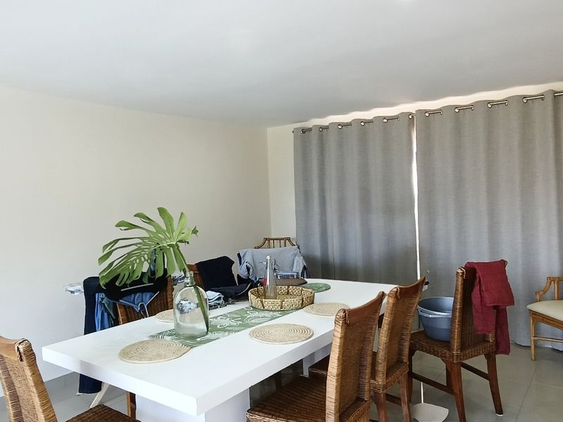 A simple dining room area featuring tiled flooring and neutral wall finishes, providing a functional space for family meals.