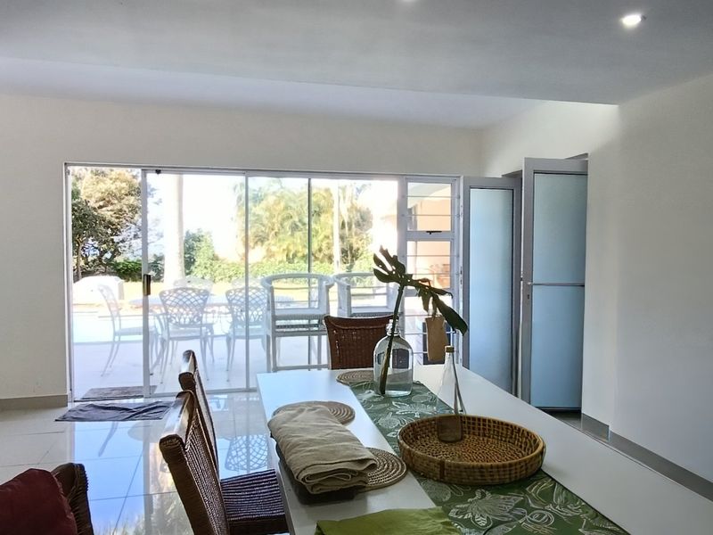 Bright living area featuring large sliding glass doors that provide natural light and direct access to the outdoor patio and pool area.
