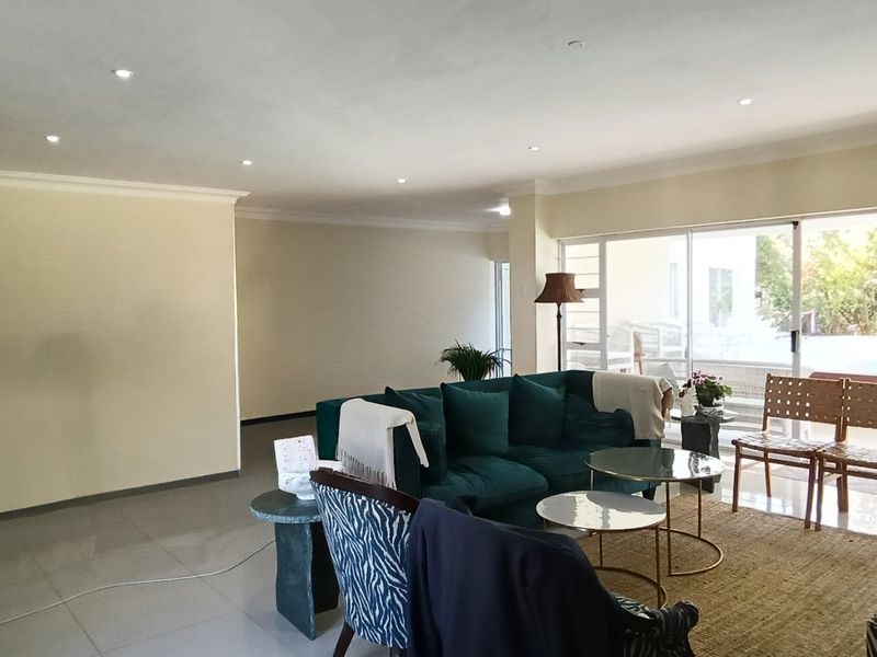 Spacious living area featuring large sliding glass doors that provide natural light and direct access to the outdoor pool area.