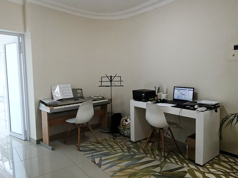 A functional home office space featuring tiled flooring and clean wall finishes, providing a versatile area for work or study.