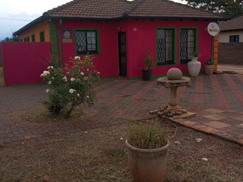 Front exterior view of a detached house featuring a tiled roof, security bars on windows, and a paved driveway area.
