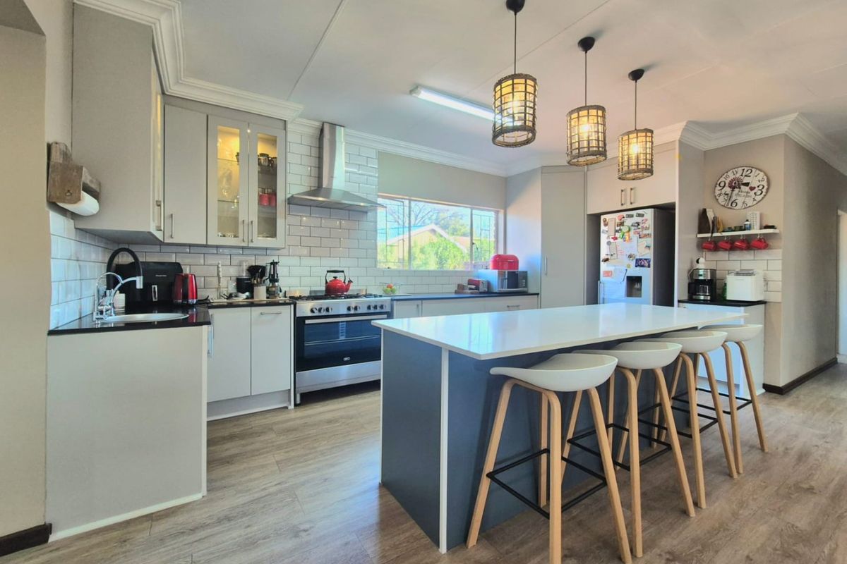 Modern kitchen featuring a central island with breakfast bar seating, subway tile backsplash, stainless steel gas stove, and ample built-in cabinetry.