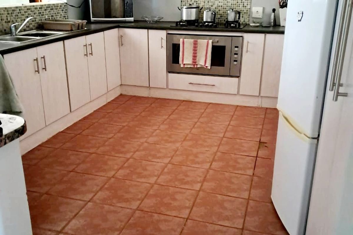 Functional kitchen featuring white cabinetry, mosaic tile backsplash, built-in oven, gas hob, and durable ceramic floor tiles.