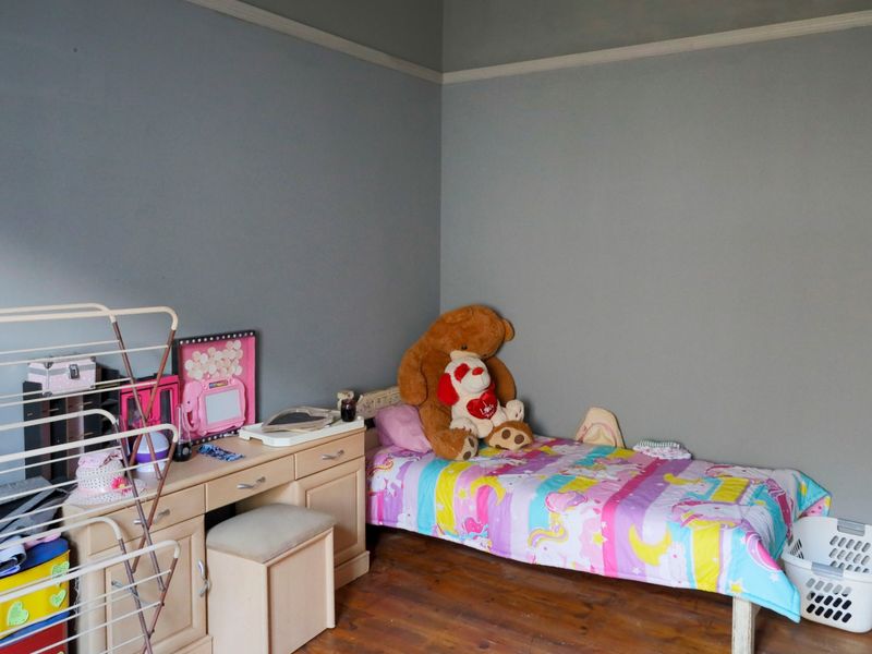 A bedroom featuring original timber flooring and a classic picture rail, offering a neutral base for personalization.