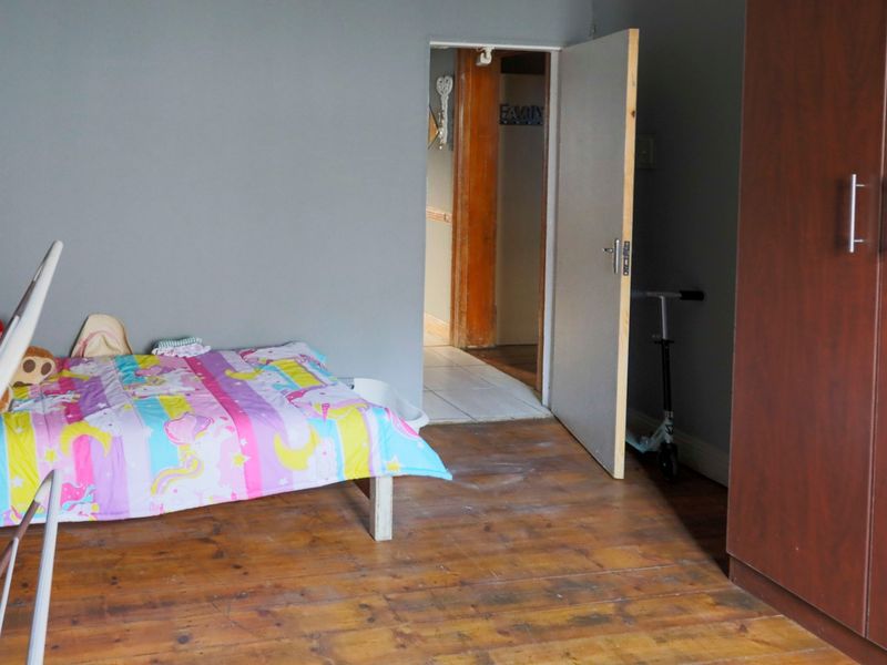 Bedroom featuring timber flooring and a built-in wardrobe, providing a functional space with potential for cosmetic updates.