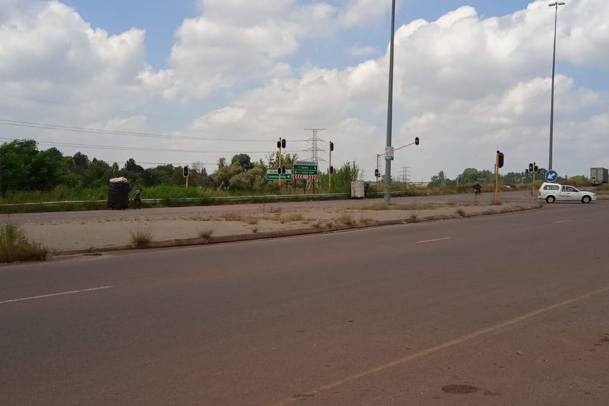 A view of the public road infrastructure and surrounding landscape adjacent to the vacant land property.