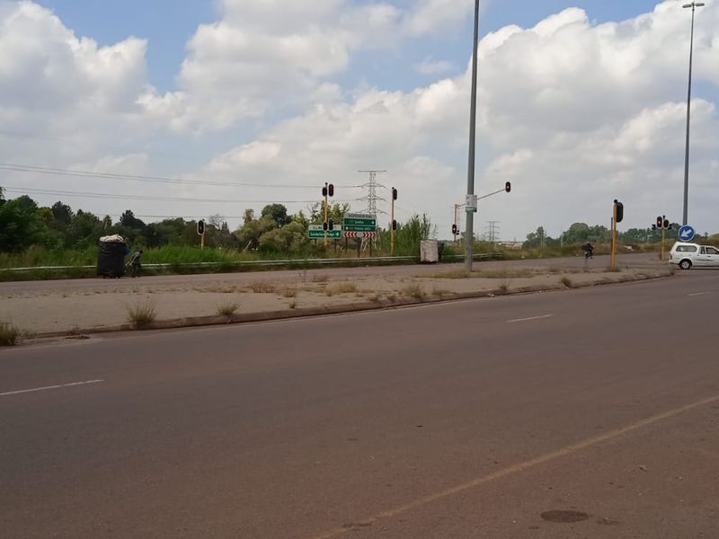 A view of the public road infrastructure and surrounding landscape adjacent to the vacant land property.