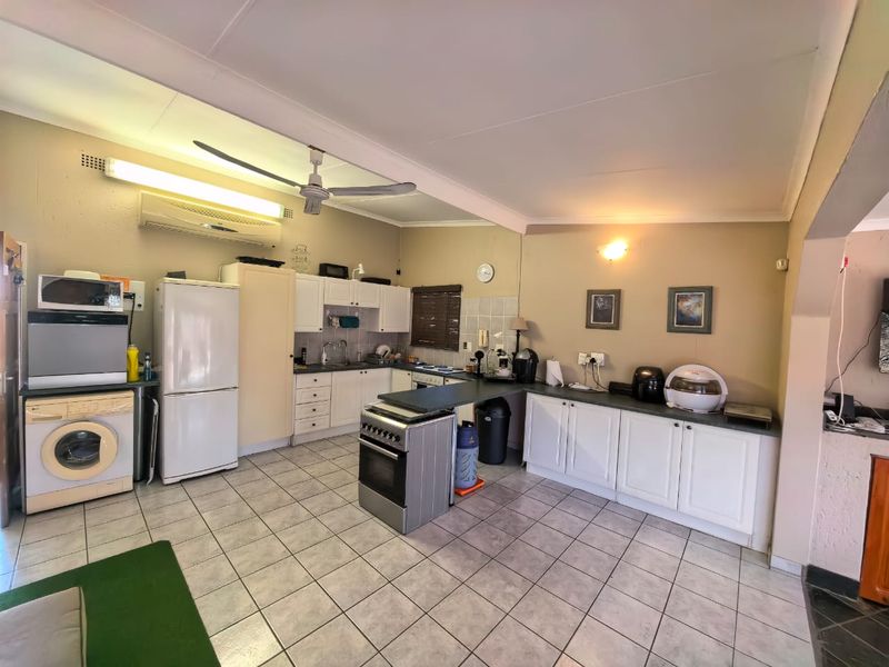 Functional kitchen featuring tiled flooring, ample built-in cabinetry, a freestanding oven, and a split-system air conditioner for climate control.
