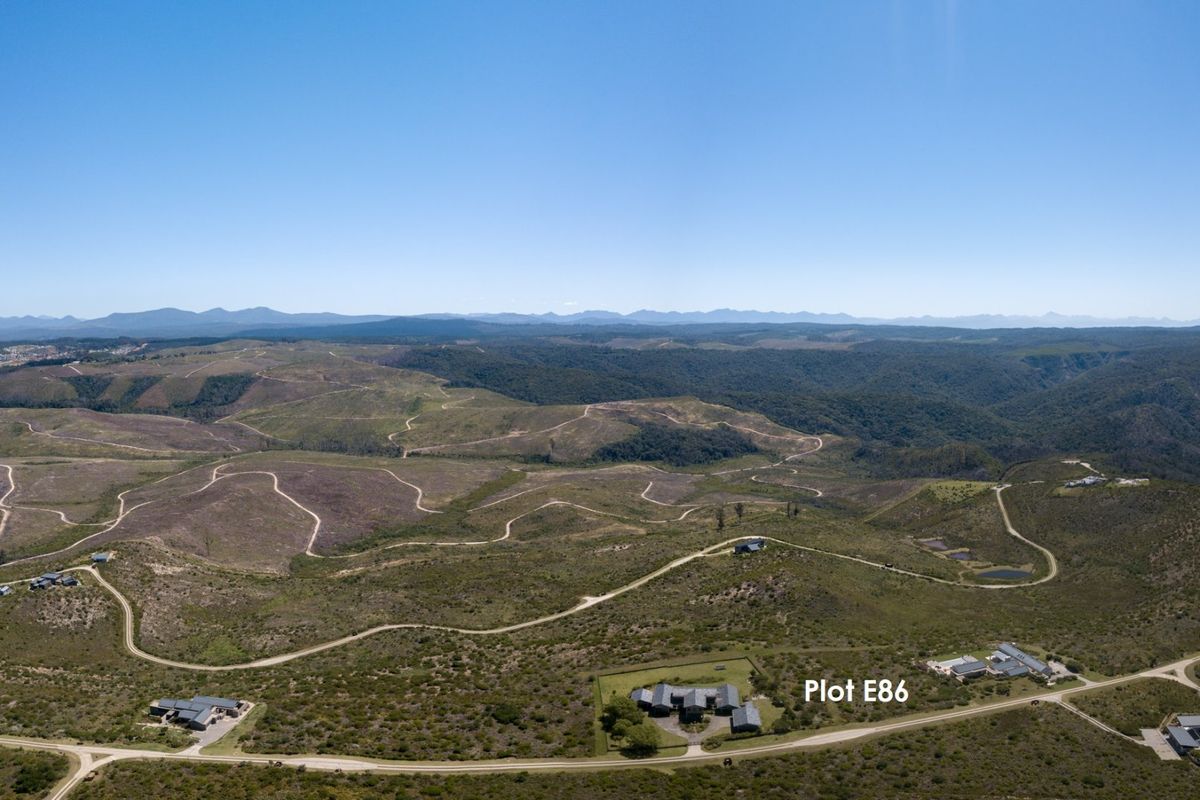 An aerial view of the rural estate landscape, highlighting the location of Plot E86 amidst the surrounding natural terrain and access roads.