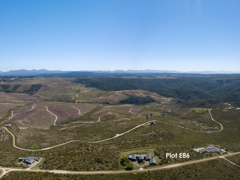 An aerial view of the rural estate landscape, highlighting the location of Plot E86 amidst the surrounding natural terrain and access roads.