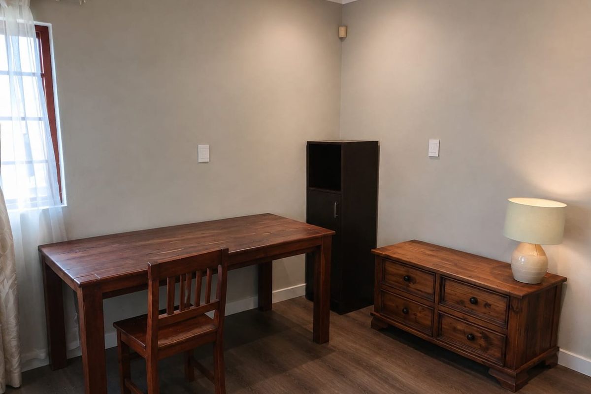 A well-maintained bedroom featuring laminate flooring, neutral wall tones, and coving, providing a clean and functional living space.