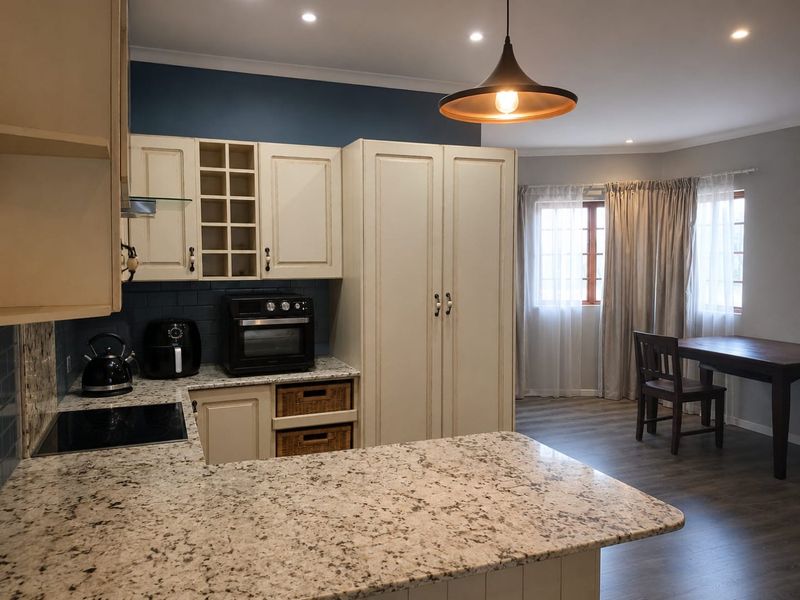 Open-plan kitchen and dining area featuring granite countertops, ample built-in cabinetry, and modern recessed lighting, creating a functional and cohesive living space.
