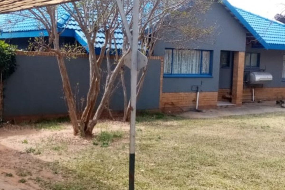 Rear view of the house featuring a tiled roof, brick and painted wall finishes, and an external geyser unit.