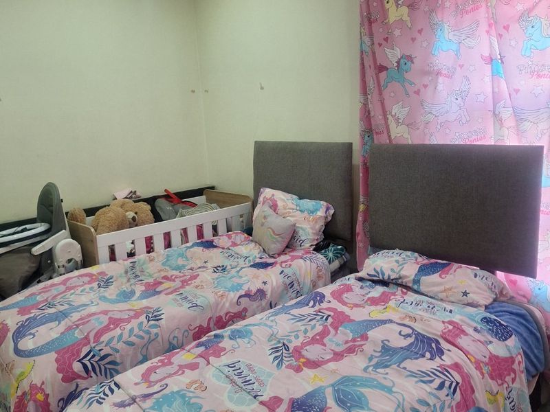 A functional bedroom featuring tiled flooring and recessed downlighting, currently configured as a children's room.