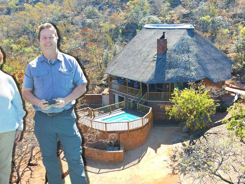 Aerial view of a thatched-roof property featuring a raised wooden deck and swimming pool, set within a natural bushveld landscape.