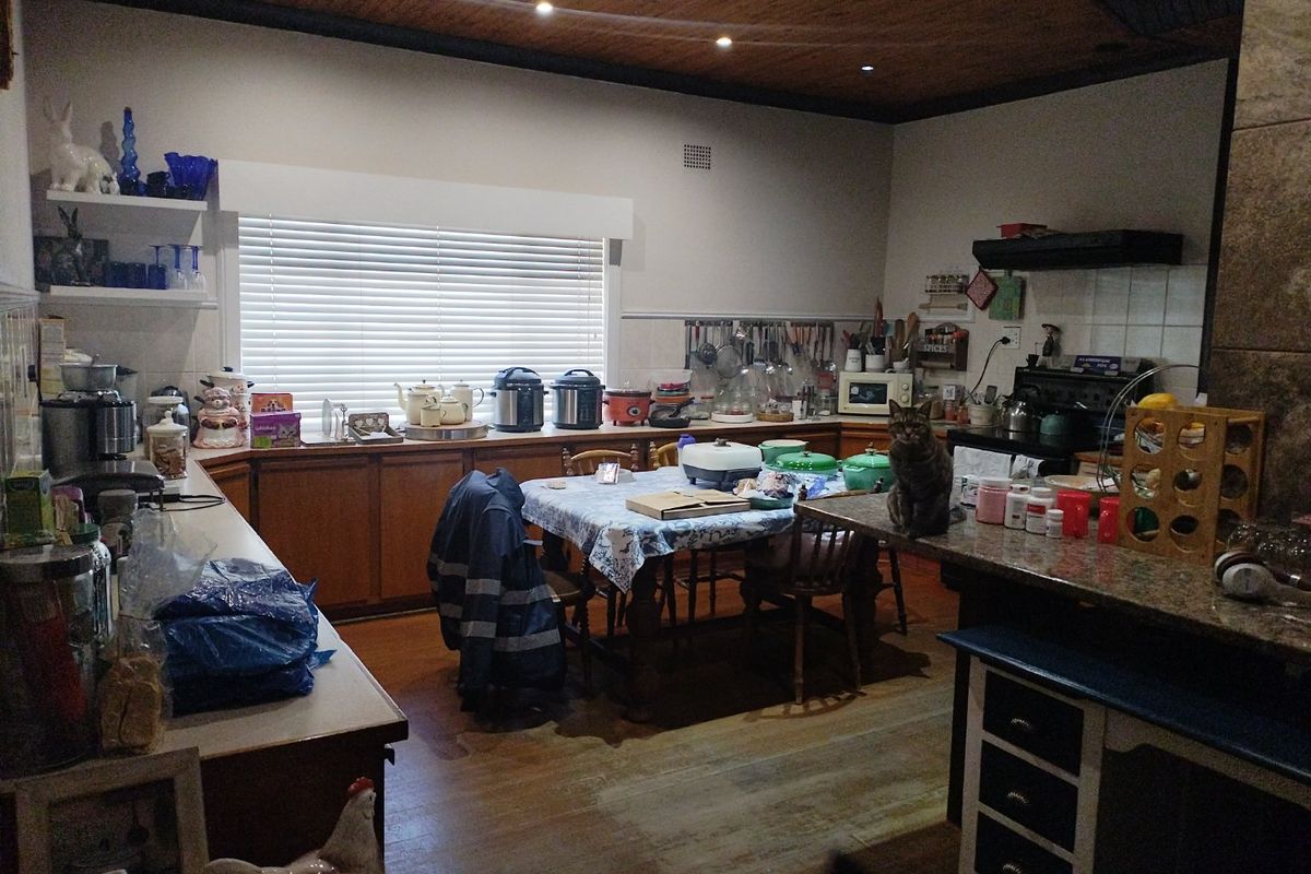 Spacious kitchen featuring wooden ceilings, granite countertops, and ample cabinetry, offering a functional layout with integrated lighting and a large window for natural light.