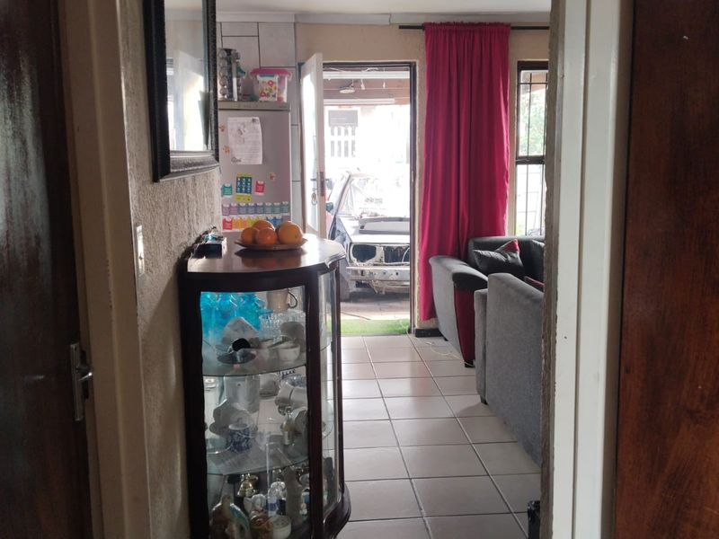 A view through a doorway into a living area with tiled flooring, showing a transition space between rooms.
