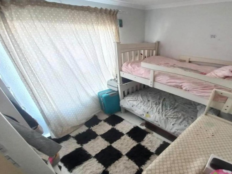 A compact bedroom featuring a sliding door with curtain rail and coving, currently utilized as a children's room.