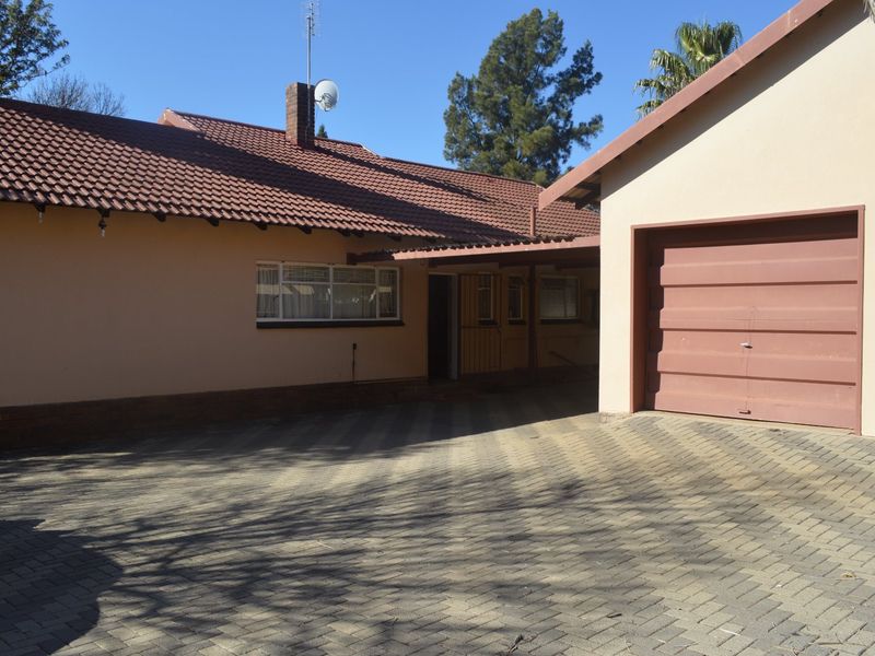 Front exterior view of the house featuring a paved driveway, a single garage, and a tiled roof structure.