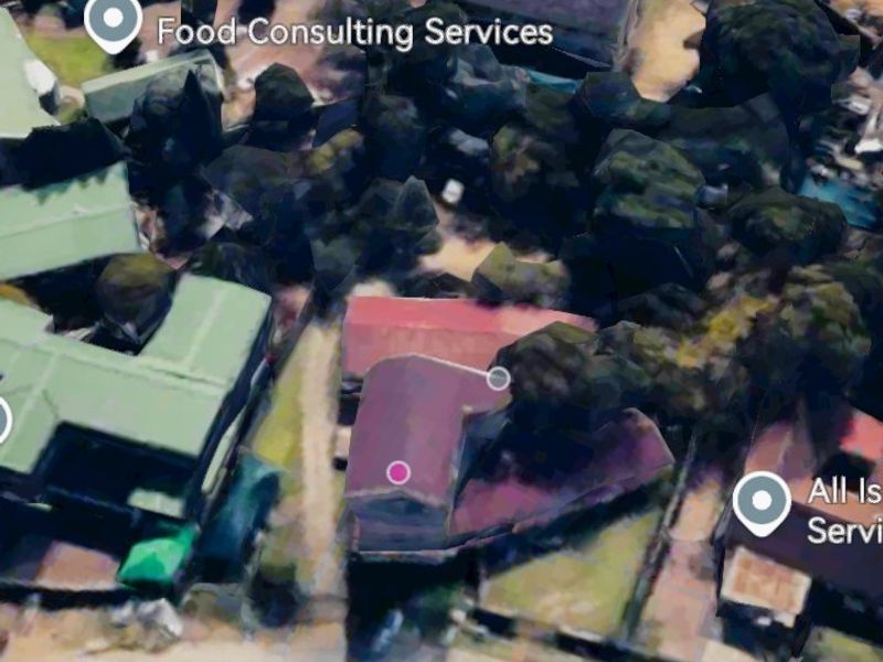 An aerial view of a commercial area featuring multiple buildings, access roads, and surrounding grounds.